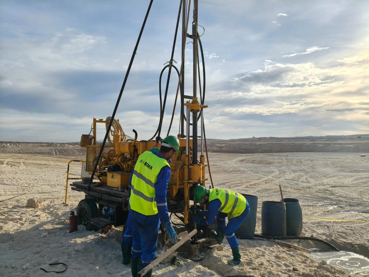 Horema drilling crew operating a rotary rig at first light on a coastal desert site in Egypt